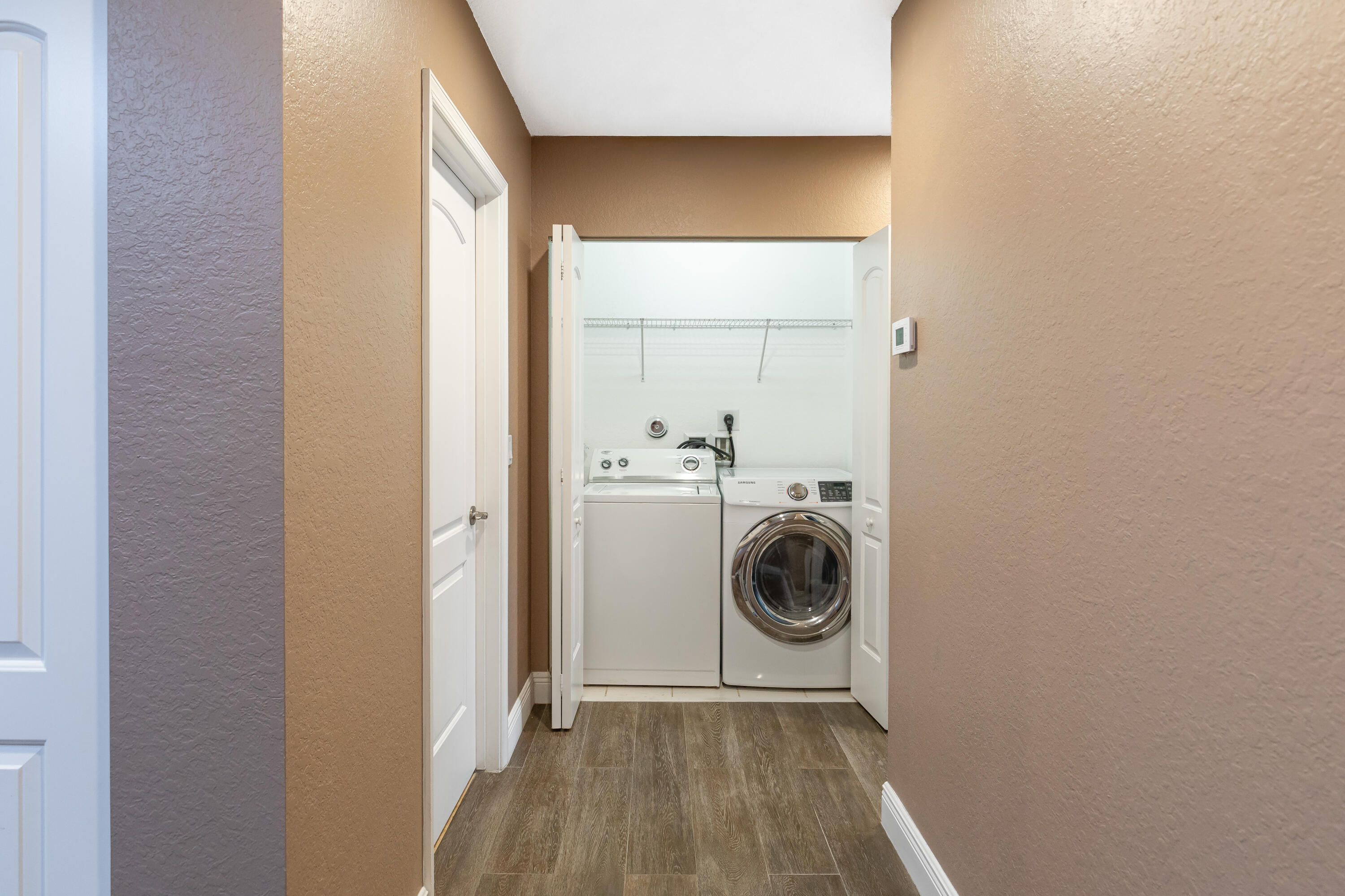 7782 Paddock Place Davie, FL 33328 - Photo 21 of 40 a utility room with washing machine and a view of bedroom