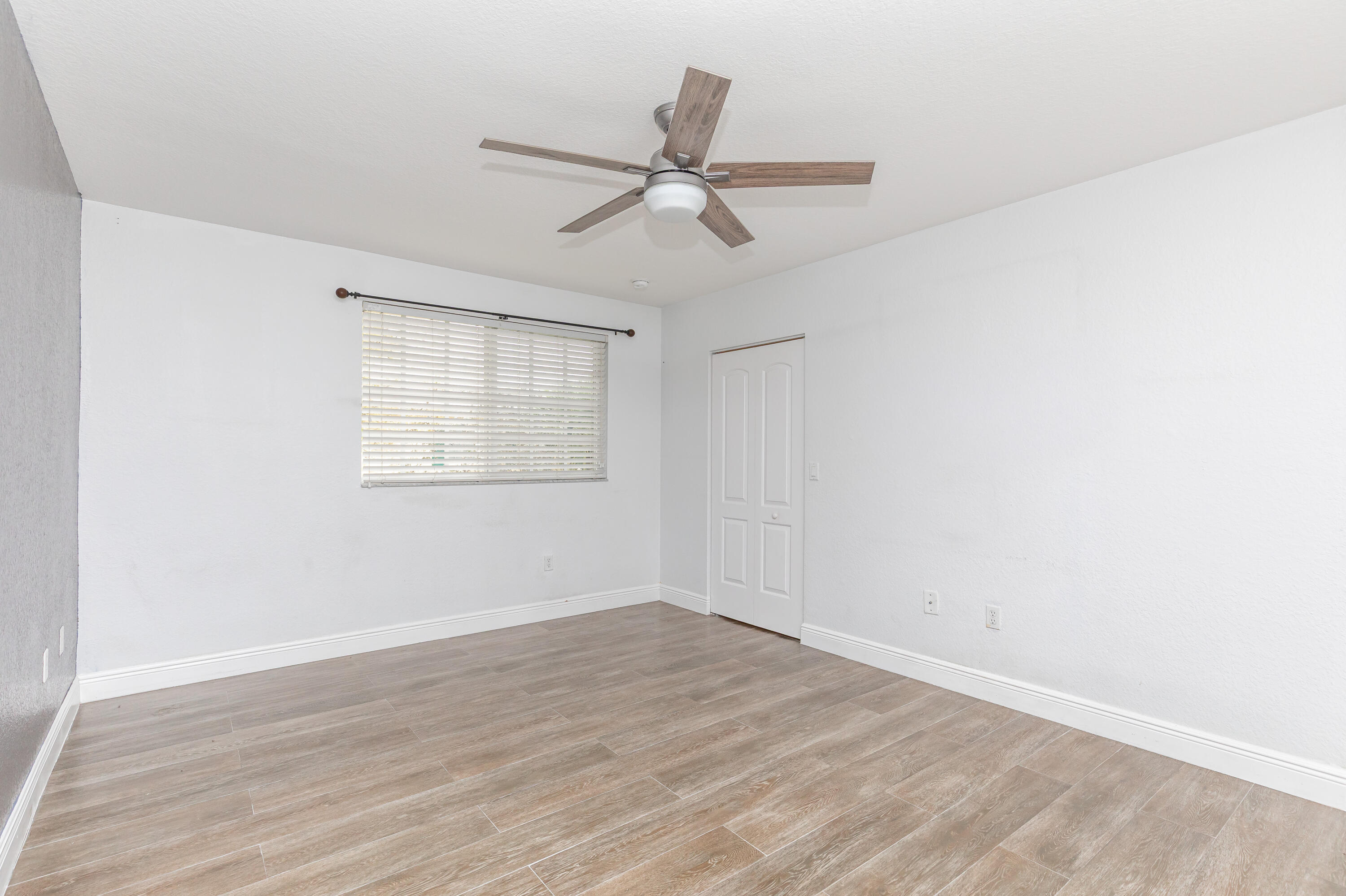 7782 Paddock Place Davie, FL 33328 - Photo 24 of 40 an empty room with wooden floor fan and windows