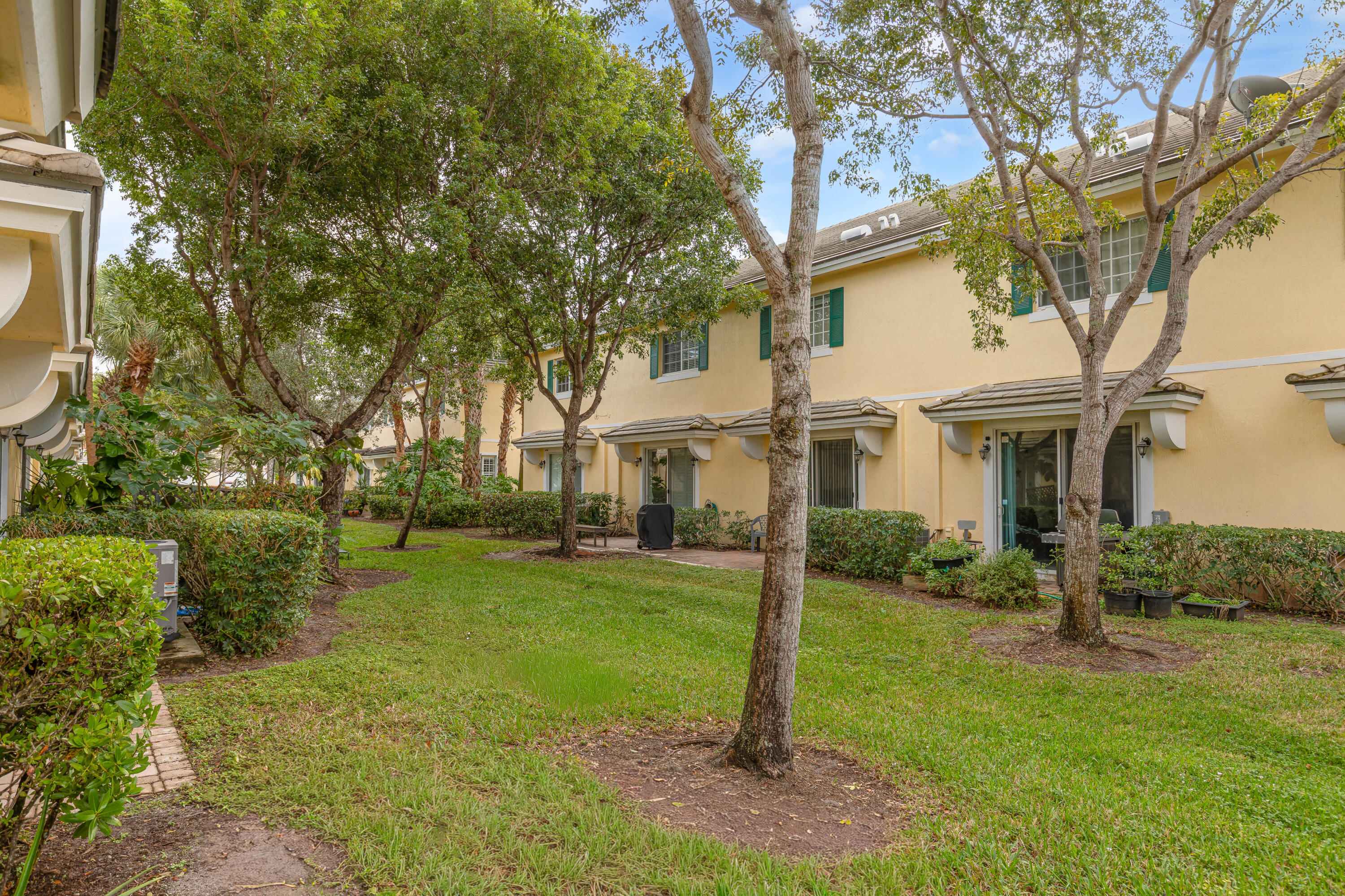 7782 Paddock Place Davie, FL 33328 - Photo 36 of 40 a view of a white house next to a yard with a tree and wooden fence