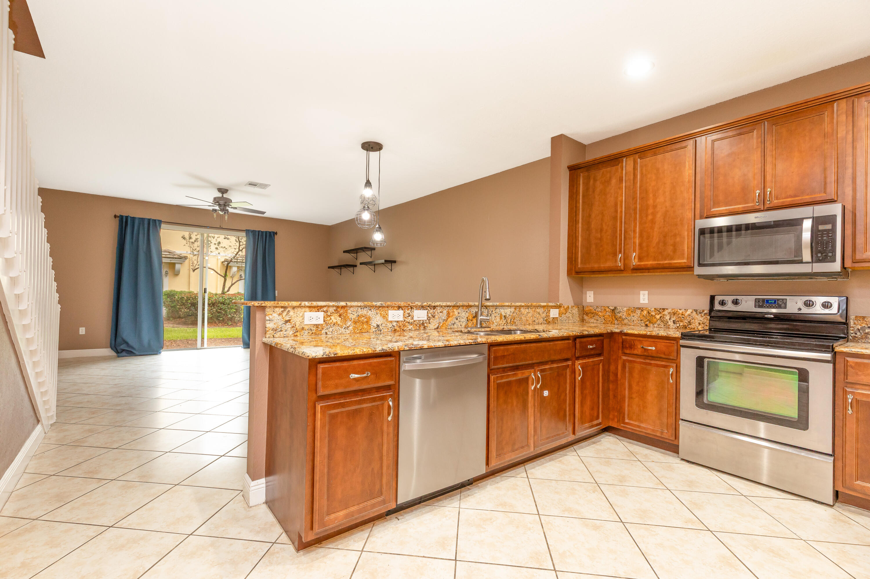 7782 Paddock Place Davie, FL 33328 - Photo 6 of 40 a kitchen with stainless steel appliances granite countertop a stove a sink and a microwave