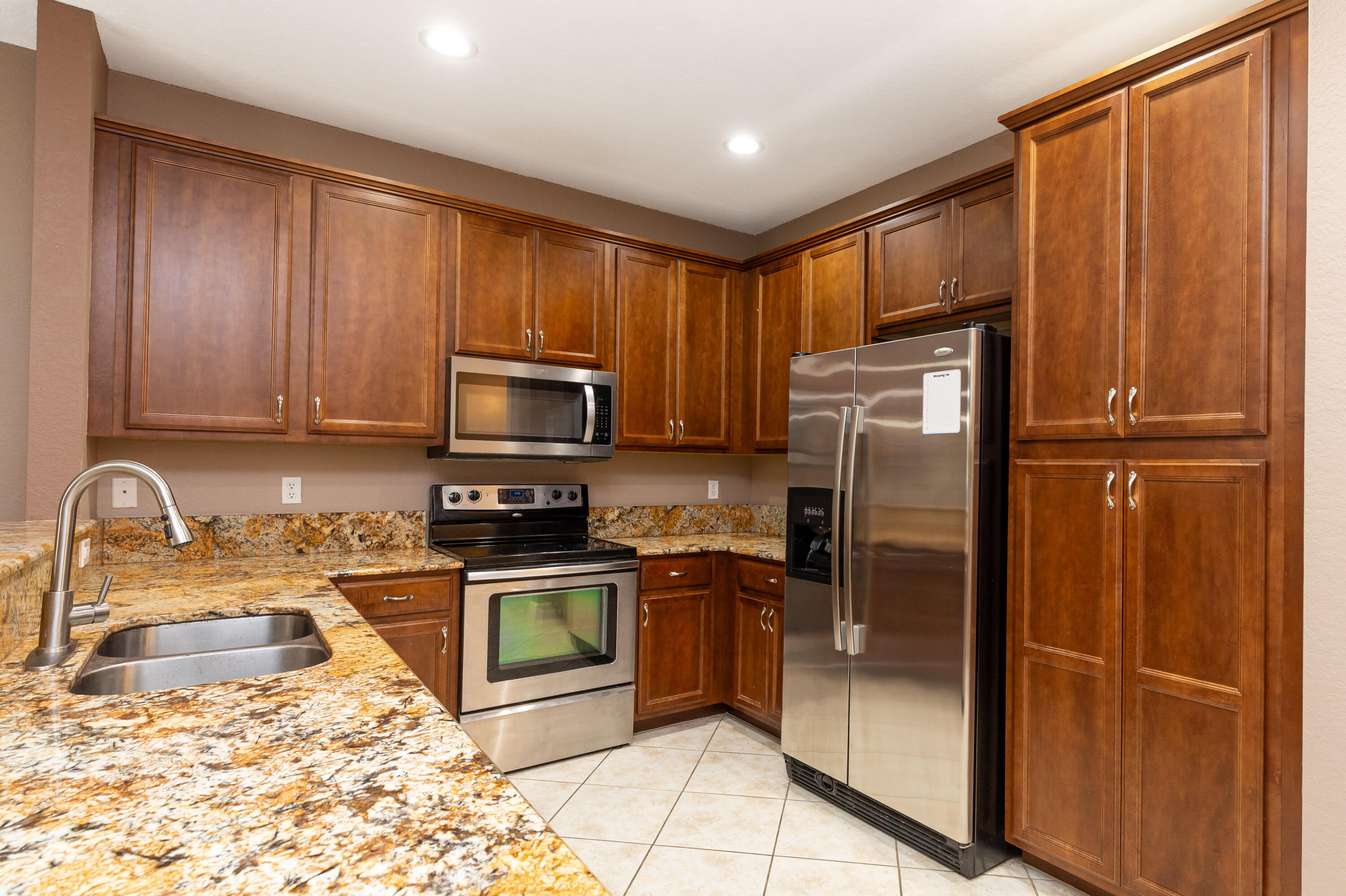 7782 Paddock Place Davie, FL 33328 - Photo 9 of 40 a kitchen with stainless steel appliances granite countertop a refrigerator a stove a sink and dishwasher