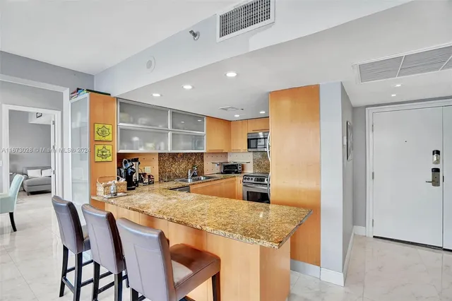 a kitchen with granite countertop kitchen island stainless steel appliances a table and chairs