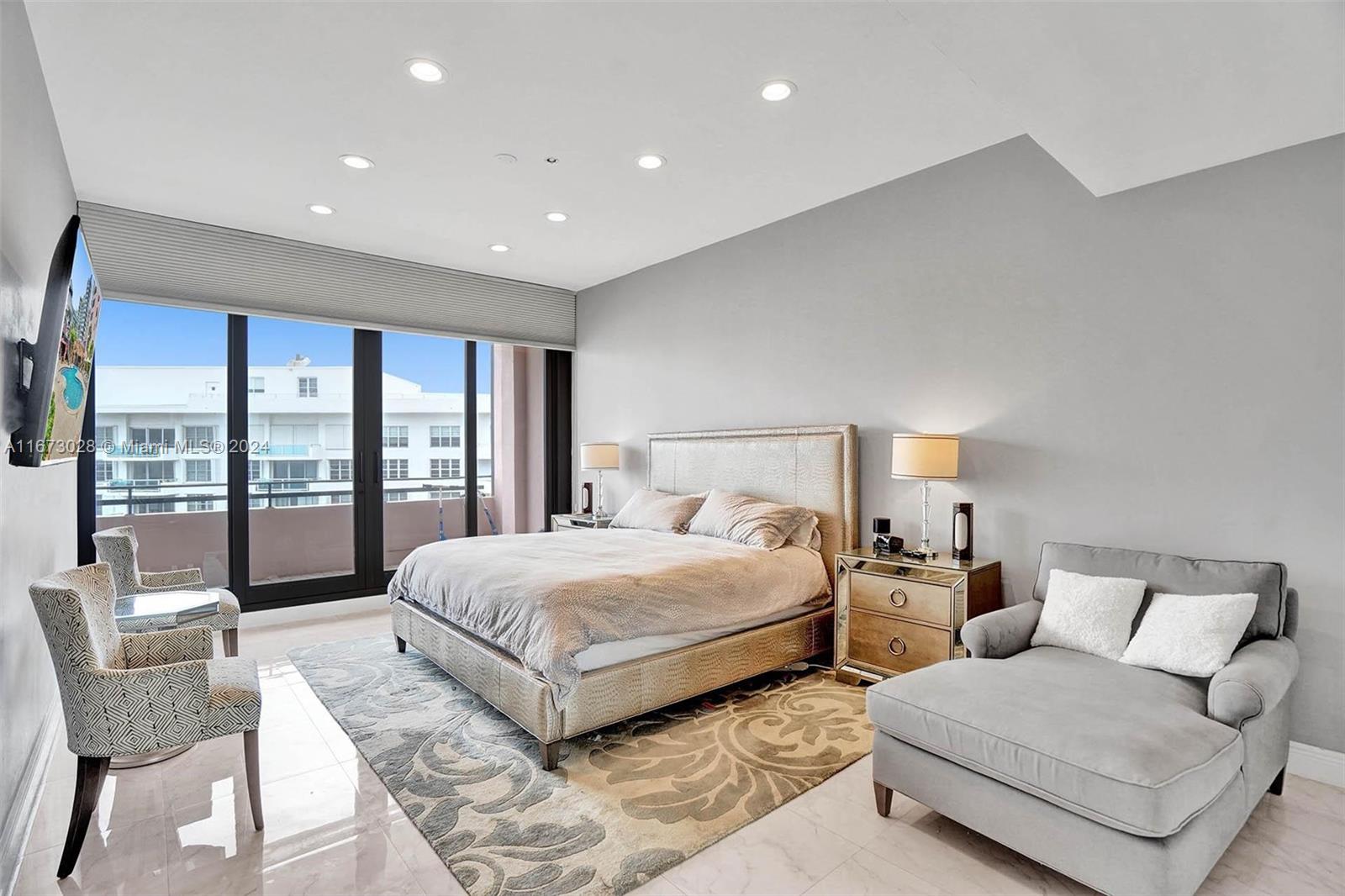 5225 Collins Avenue, Unit PH7 Miami Beach, FL 33140 - Photo 15 of 50 a spacious bedroom with a large bed and a large window