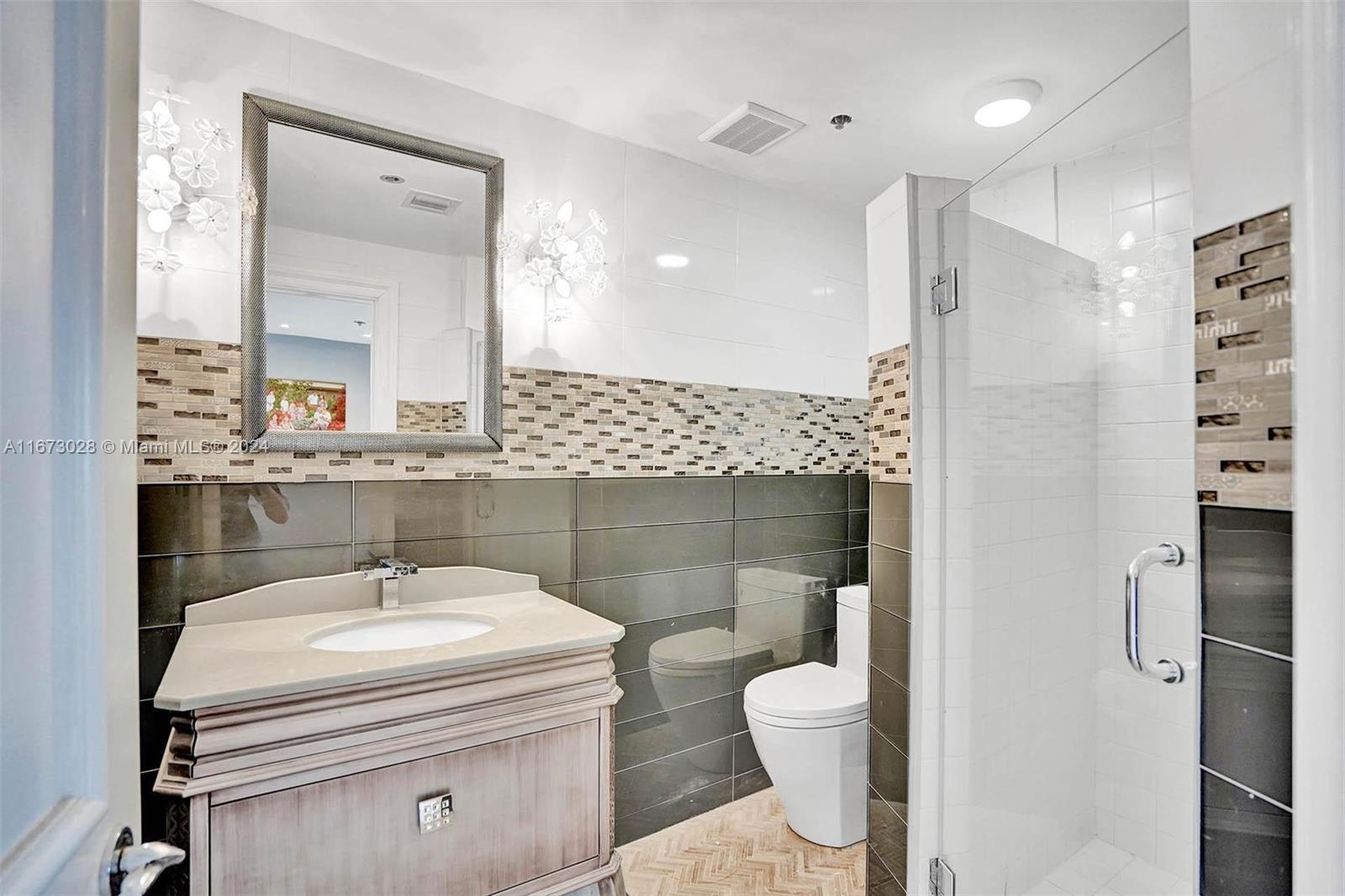 5225 Collins Avenue, Unit PH7 Miami Beach, FL 33140 - Photo 24 of 50 a bathroom with a sink a toilet and a mirror