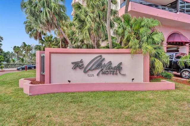 a front view of multi story residential apartment building with yard and entryway