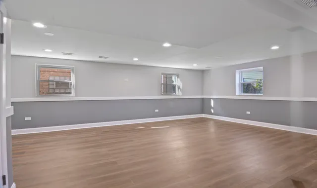 a view of an empty room with wooden floor and closet
