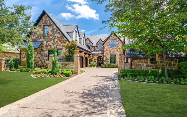 a front view of a house with a yard and trees
