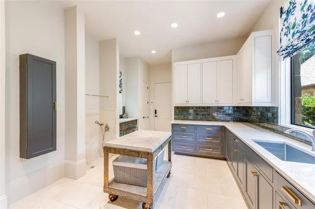 a large kitchen with kitchen island a sink stainless steel appliances and cabinets