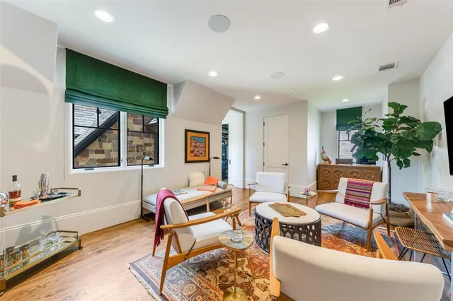 a living room with furniture a potted plant and a large window