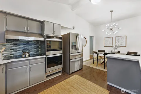 a kitchen with stainless steel appliances kitchen island granite countertop a refrigerator and a stove top oven