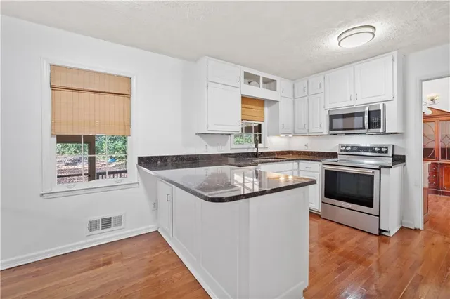 a kitchen with stainless steel appliances granite countertop a sink stove and microwave
