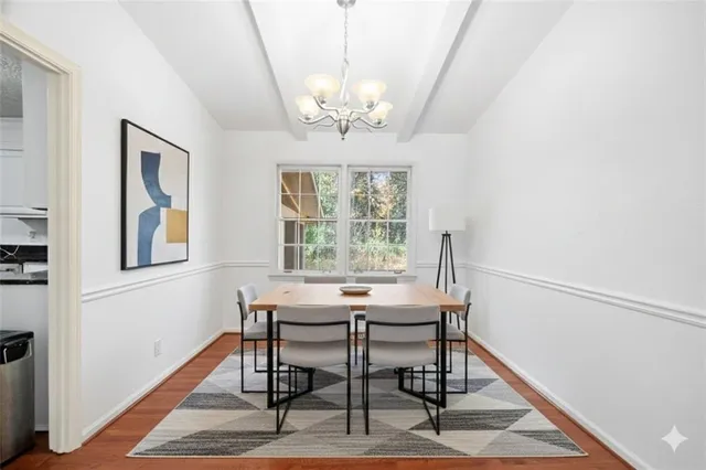 a view of a dining room with furniture a chandelier and wooden floor
