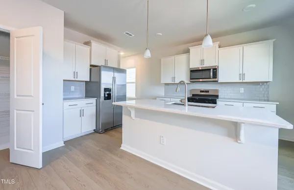 a kitchen with stainless steel appliances a sink a stove a refrigerator and cabinets