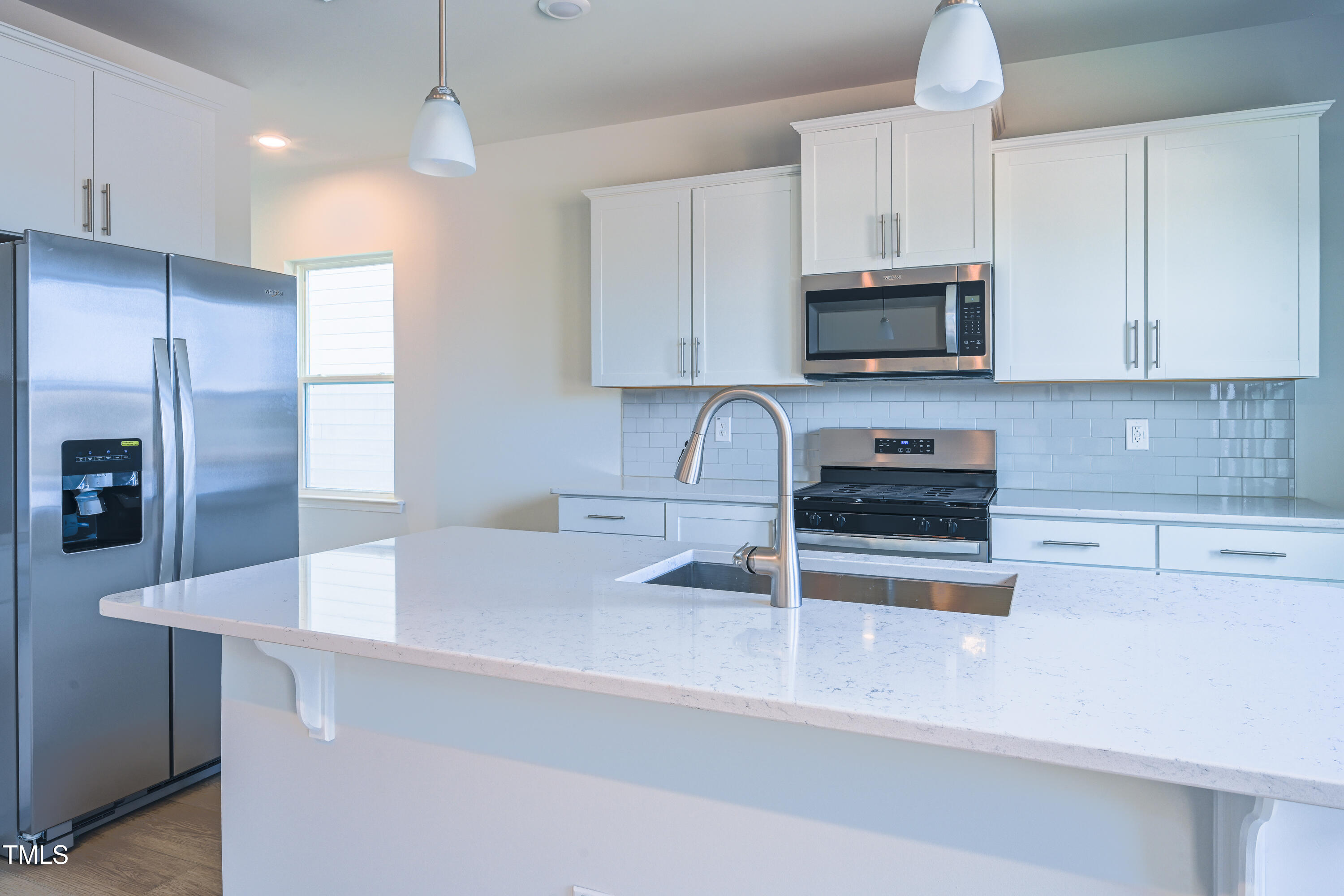 1511 Tamarisk Lane Durham, NC 27703 - Photo 15 of 26 a kitchen with stainless steel appliances a sink a stove a refrigerator and cabinets