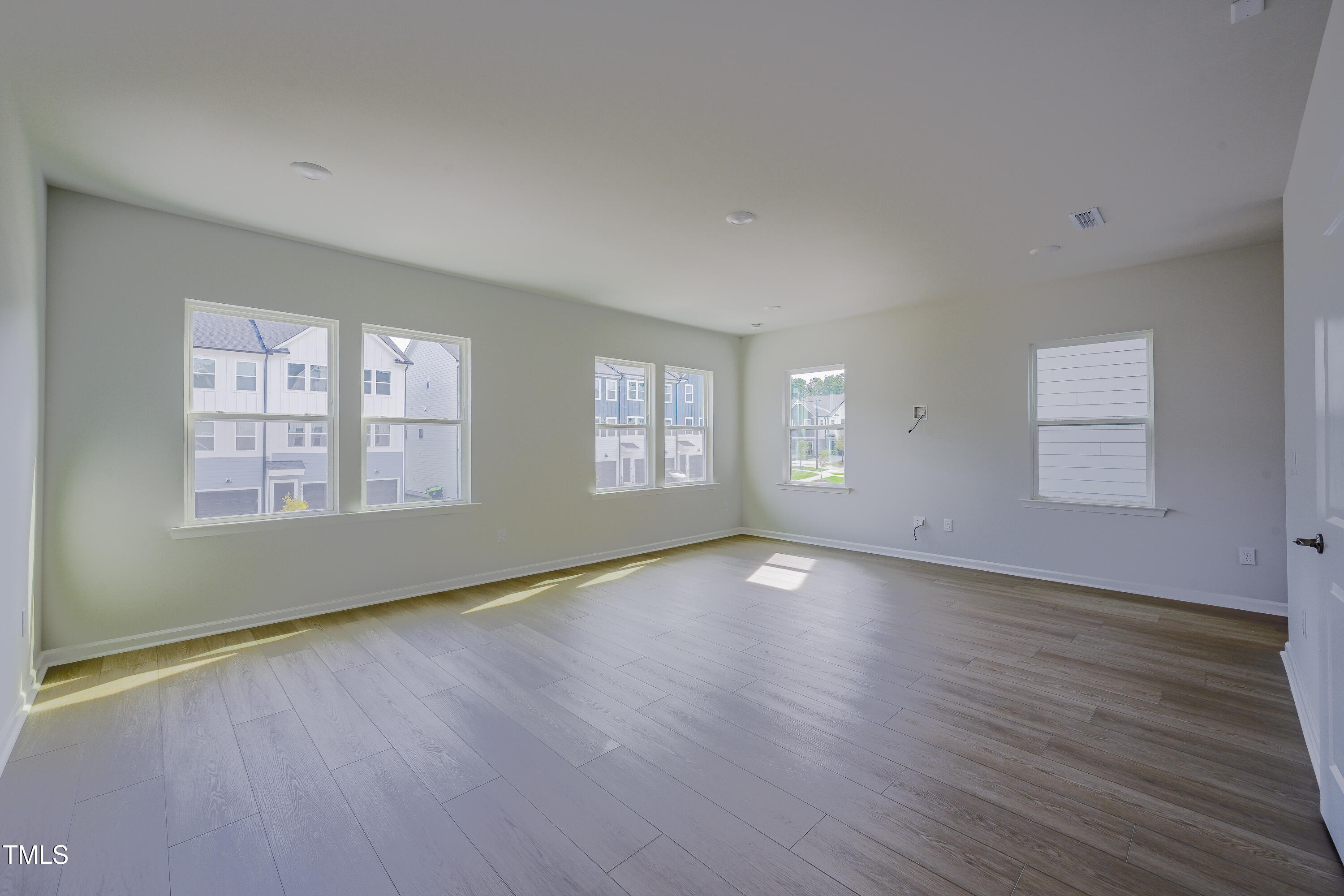 1511 Tamarisk Lane Durham, NC 27703 - Photo 18 of 26 an empty room with wooden floor and windows