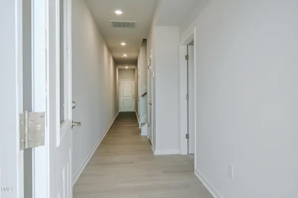 a view of a hallway with wooden floor and staircase