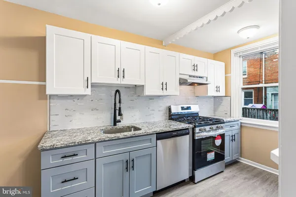 a kitchen with granite countertop white cabinets and white appliances