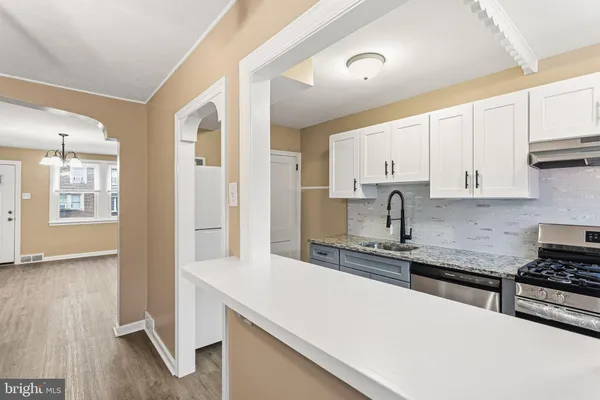 a kitchen with stainless steel appliances granite countertop a sink and cabinets with wooden floor