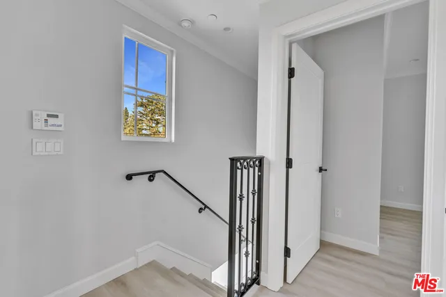 a view of a hallway with wooden floor and stairs