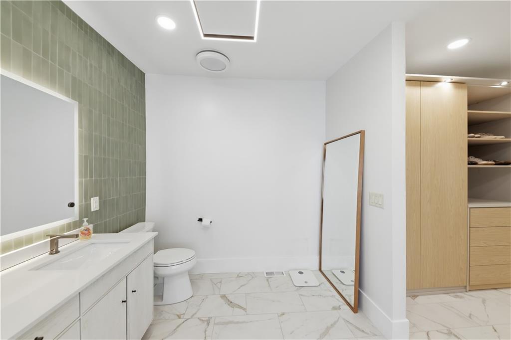 505 Hollydale Court Northwest Atlanta, GA 30342 - Photo 53 of 117 a bathroom with a granite countertop sink a toilet and a mirror