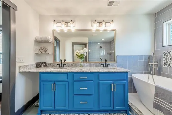 a bathroom with a granite countertop sink mirror and bathtub