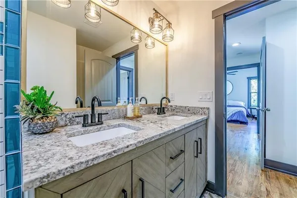 a bathroom with a granite countertop sink a mirror and a potted plant