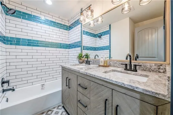 a bathroom with a granite countertop sink and a bathtub