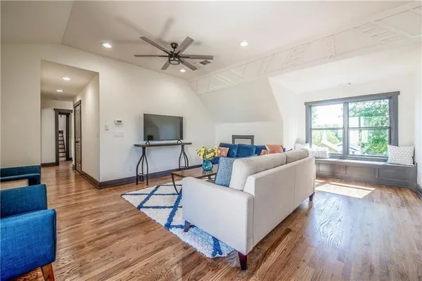a living room with furniture and a flat screen tv with wooden floor