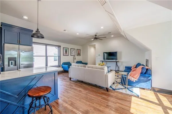 a living room with furniture a flat screen tv and wooden floor