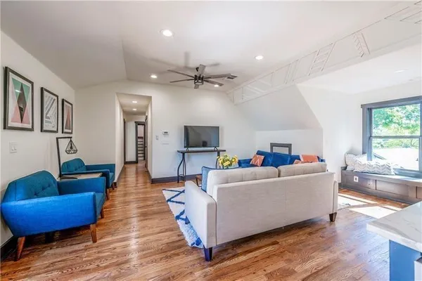 a living room with furniture and a wooden floor