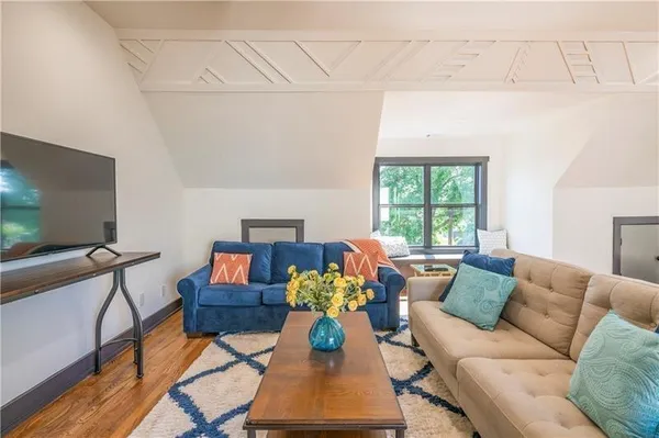 a living room with furniture a flat screen tv and a window