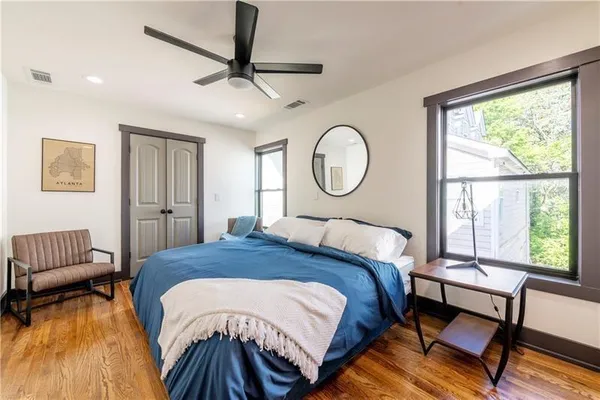 a bedroom with a bed a couch and a large window