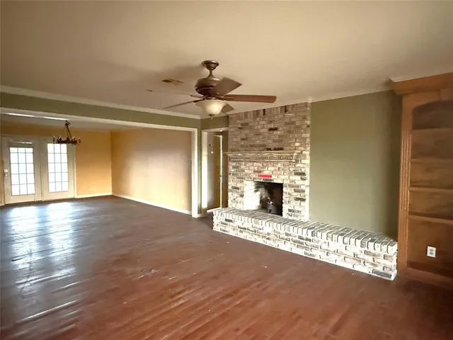 a view of a livingroom with a fireplace wooden floor and a window