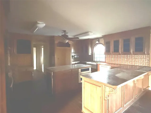 a kitchen with stainless steel appliances kitchen island granite countertop a sink and cabinets