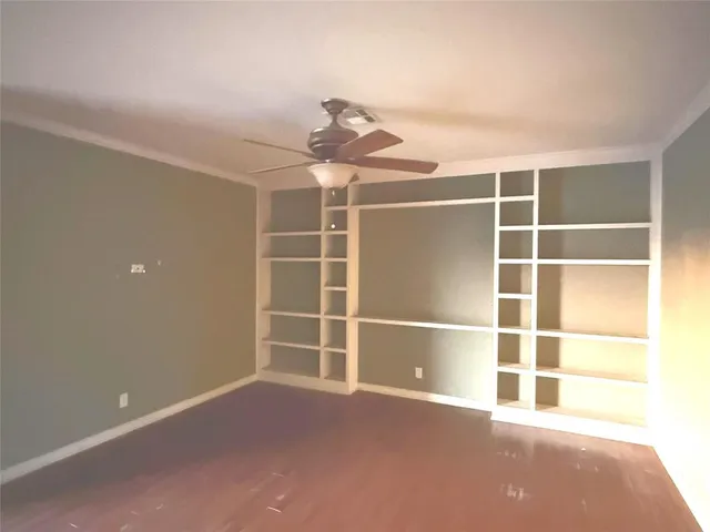 a view of an empty room with a window and a ceiling fan