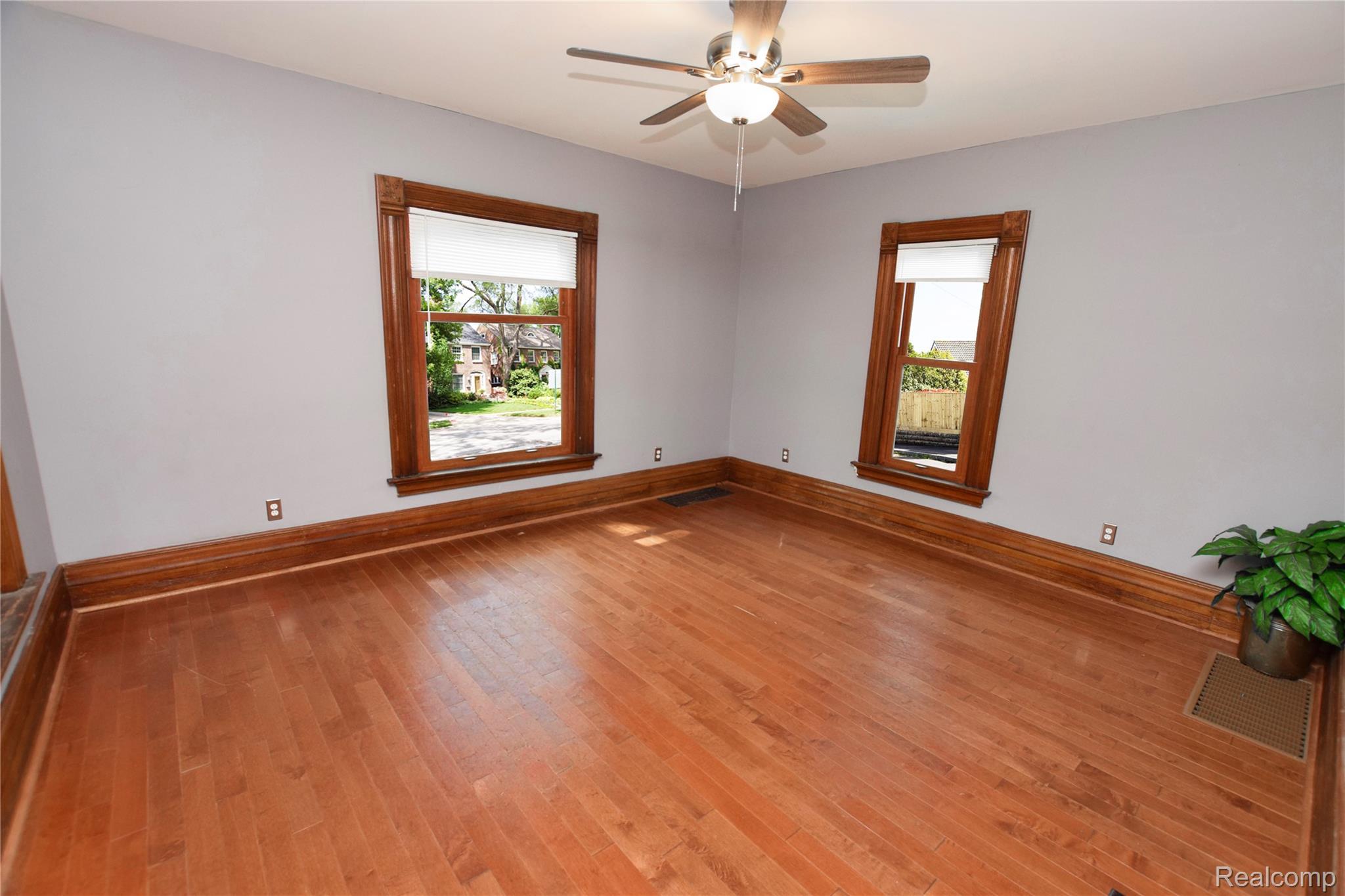 404 North Adelaide Street Fenton, MI 48430 - Photo 6 of 23 Spacious room featuring wood-finish flooring, two windows with white shades, and dark wood trim