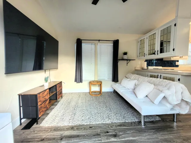 a large living room with stainless steel appliances kitchen island granite countertop furniture and a kitchen view