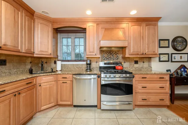 a kitchen with stainless steel appliances granite countertop a refrigerator a sink and white cabinets