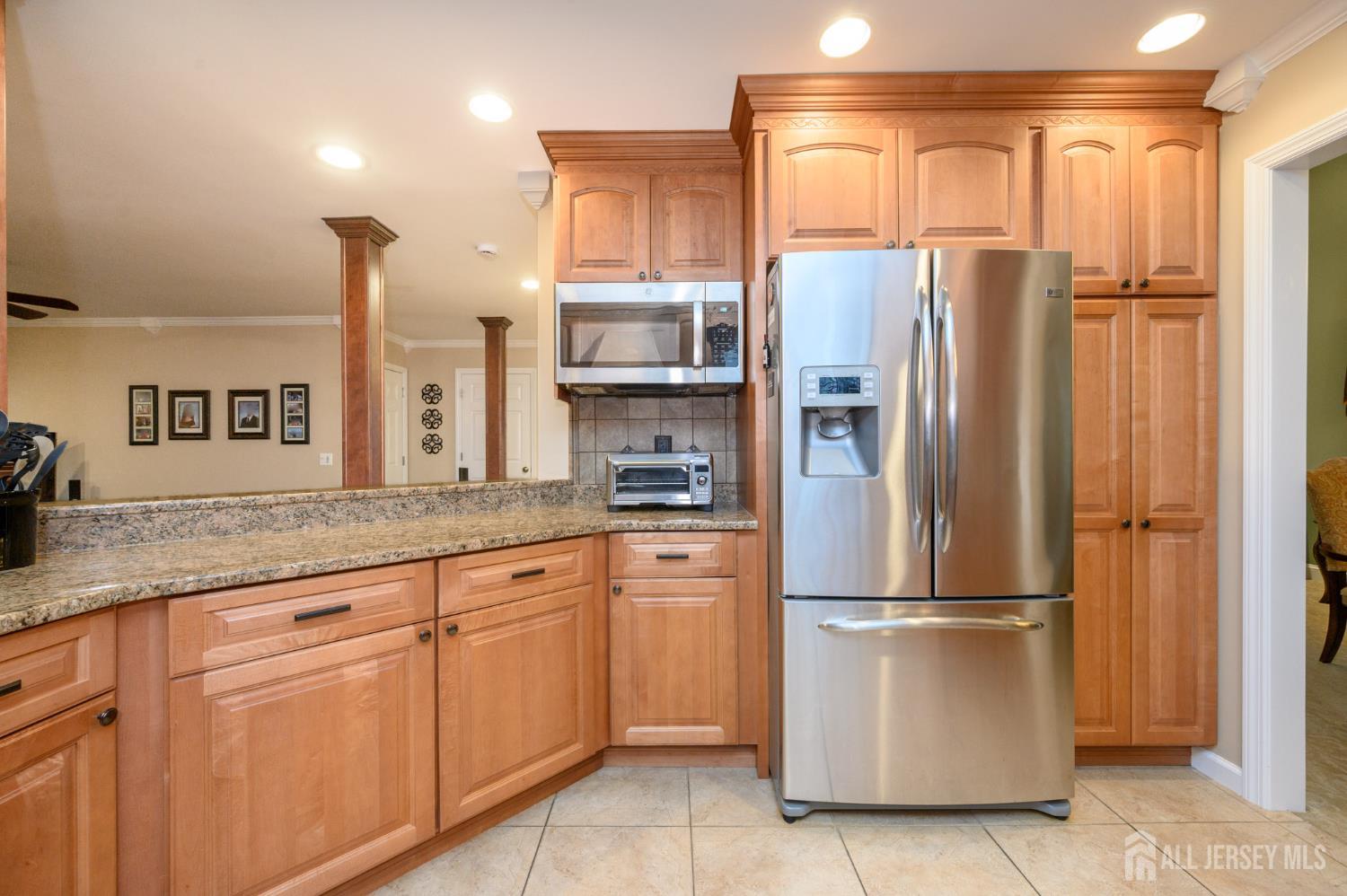 12 Diamond Lane Howell, NJ 07731 - Photo 13 of 47 a kitchen with stainless steel appliances granite countertop a refrigerator a sink and white cabinets