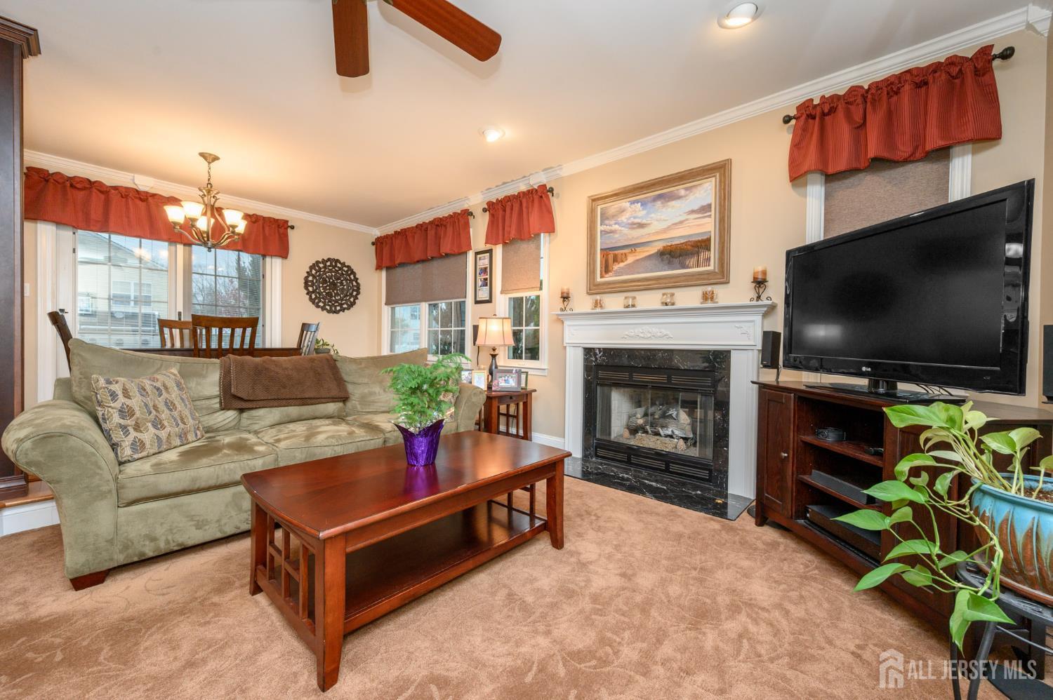 12 Diamond Lane Howell, NJ 07731 - Photo 17 of 47 a living room with furniture a flat screen tv and a fireplace