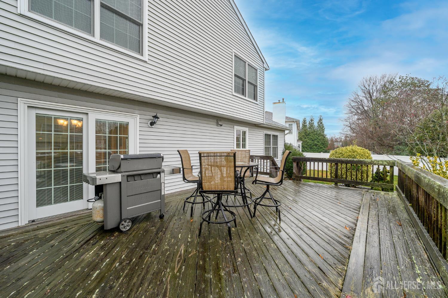 12 Diamond Lane Howell, NJ 07731 - Photo 40 of 47 a view of a roof deck with table and chairs floor to ceiling window with wooden floor