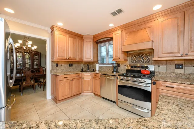 a kitchen with stainless steel appliances kitchen island granite countertop a sink and cabinets