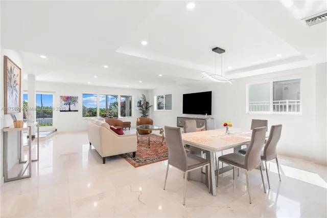 a large kitchen with kitchen island a large window in it