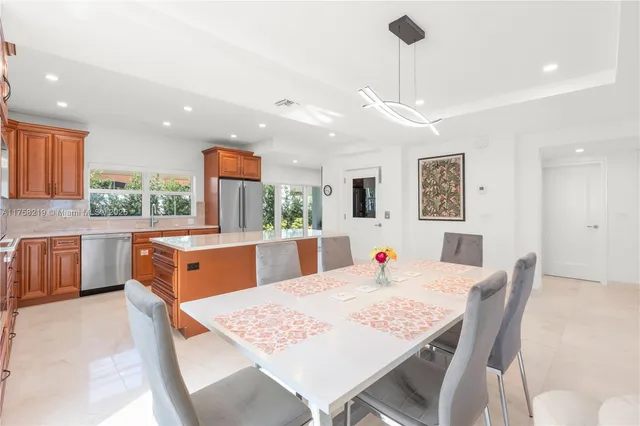 a large kitchen with stainless steel appliances granite countertop a refrigerator a oven and a sink with wooden cabinets