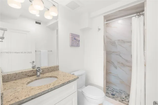 a bathroom with a granite countertop sink a shower and a mirror