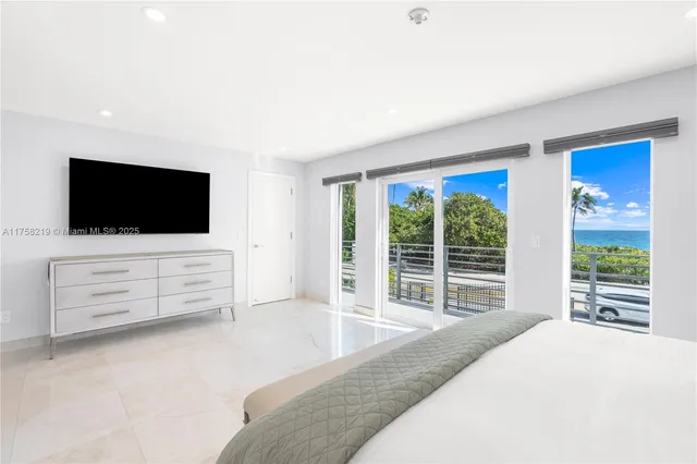 a kitchen with stainless steel appliances granite countertop a sink a refrigerator and a white cabinets with wooden floor