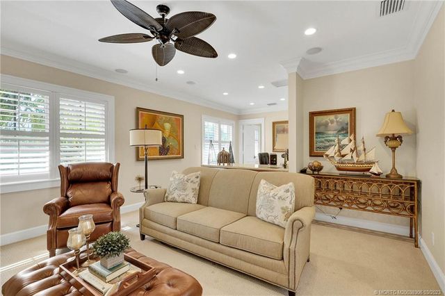 a view of a house with a yard and palm trees