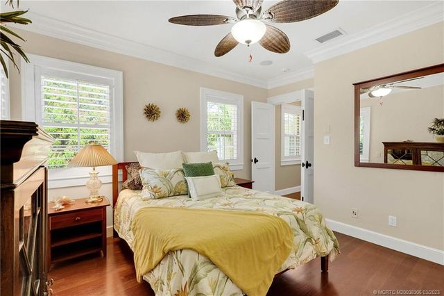 a front view of a house with a garden and trees