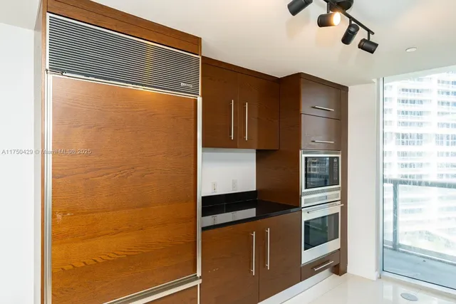 a kitchen with granite countertop a refrigerator and a sink