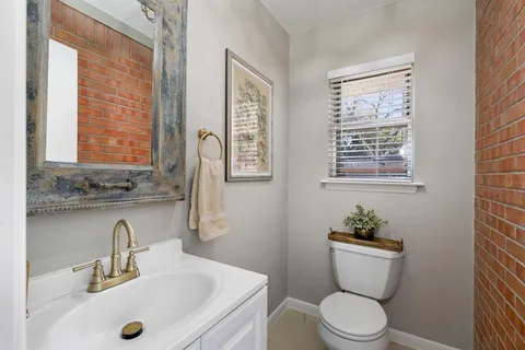 a bathroom with a granite countertop toilet sink and mirror